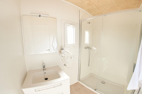 Lyst og moderne badeværelse i mobilhjemmet Els Pins- Mobile-Home Plus 3 i Spanien, med bruser og vask.