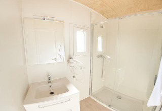 Lyst og moderne badeværelse i mobilhjemmet Els Pins- Mobile-Home Plus 3 i Spanien, med bruser og vask.