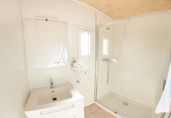 Baño moderno y luminoso con ducha y lavabo en Els Pins- Mobile-Home Plus 3, casa móvil en España.