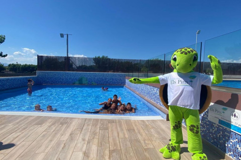 Children swimming in the pool at Els Pins- Bungalow Comfort, Spain, with a turtle mascot beside the pool.