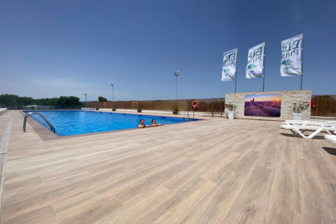 Outdoor swimming pool at Els Pins- Bungalow Comfort lodge in Spain with loungers and clear blue water.