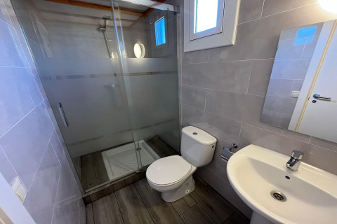 Contemporary bathroom at Els Pins-Bungalow Comfort in Spain with shower, toilet, and a washbasin.