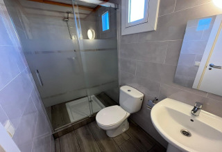 Contemporary bathroom at Els Pins-Bungalow Comfort in Spain with shower, toilet, and a washbasin.