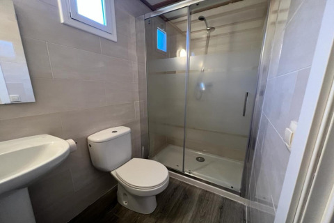 Modern bathroom at Els Pins- Bungalow Comfort in Spain with shower, toilet, and sink visible.