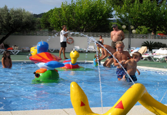 Børn leger i en pools med farverige vandlegetøj på Camping Rocagrossa Mobile Home i Spanien.