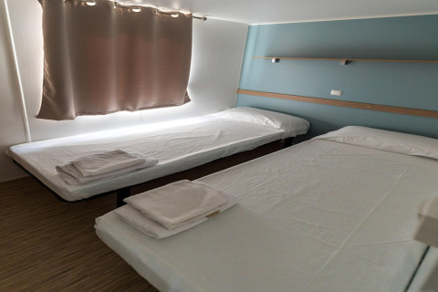 Twee eenpersoonsbedden met wit beddengoed in Camping Rocagrossa Mobile Home voor 6 personen in Spanje.