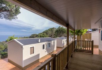 Vista dal portico di Camping Rocagrossa Mobile Home per 6 persone, immerso nel verde, in Spagna.