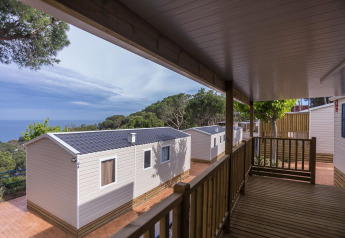 Vista dal portico di Camping Rocagrossa Mobile Home per 6 persone, immerso nel verde, in Spagna.