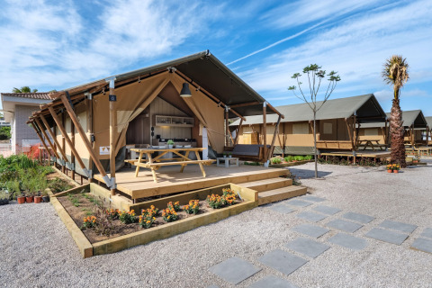 Safari-teltet CAMPING ESTIVAL VENDRELL PLATJA TENT GRAND SAFARI GLAMPING med terrasse og picnicbord.