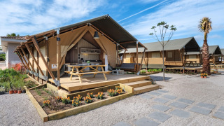 Tente safari au CAMPING ESTIVAL VENDRELL PLATJA TENT GRAND SAFARI GLAMPING avec terrasse et table de pique-nique.