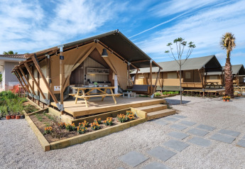 Tente safari au CAMPING ESTIVAL VENDRELL PLATJA TENT GRAND SAFARI GLAMPING avec terrasse et table de pique-nique.