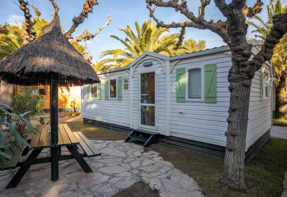 Vista exterior de Torre del Sol COTTAGE ACACIA con mesa de picnic techada y contraventanas verdes.