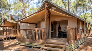 Tenda safari Torre del Sol TIENDA SAVANNAH con veranda in legno e tendalino immersa nella natura.