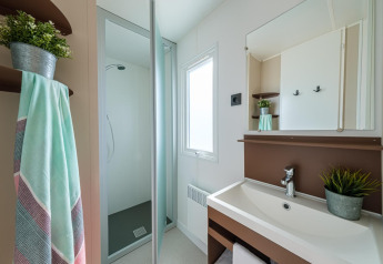 Modernes Badezimmer im Mobilheim Camping Estival Vendrell Platja in Spanien, mit Dusche und Waschbecken.