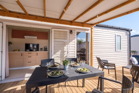 Essbereich auf der Terrasse und moderne Küche im Mobilheim auf CAMPING ESTIVAL VENDRELL PLATJA, Spanien.