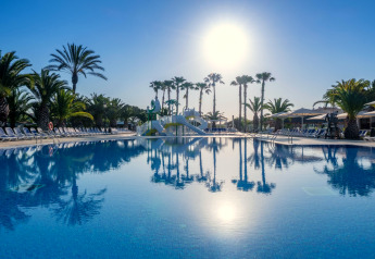 Piscina all'aperto presso Camping Estival Vendrell Platja casa mobile in Spagna con palme e sole