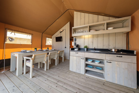 Indvendigt billede af et luksuriøst glamping-safaritelts køkken og spiseplads i Spanien.