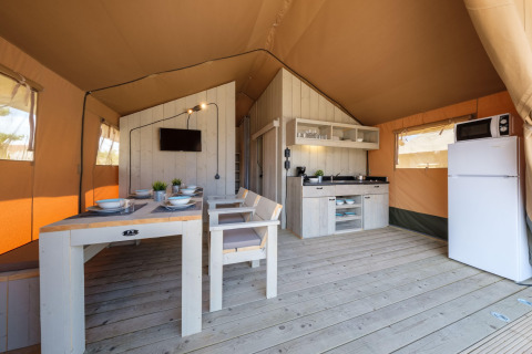 Lys og rummelig indretning af et Grand Safari Glamping telt ved Camping Estival Vendrell Plajta i Spanien.