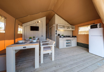 Interno luminoso e spazioso di una tenda Grand Safari Glamping al Camping Estival Vendrell Plajta in Spagna.