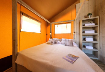 Vista interna di CAMPING ESTIVAL VENDRELL PLATJA TENT GRAND SAFARI GLAMPING in Spagna con letto e asciugamani.
