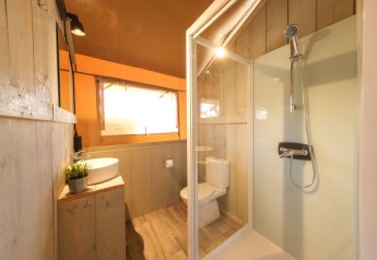 Modernes Badezimmer mit Dusche, Waschbecken und Toilette im Grand Safari Glamping Zelt in Spanien.