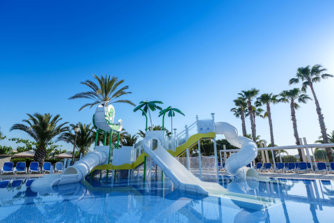Parc aquatique avec toboggans et palmiers au Camping Estival Vendrell Platja Tent Grand Safari Glamping en Espagne.