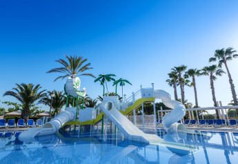 Wasserpark mit Rutschen und Palmen im Camping Estival Vendrell Platja Tent Grand Safari Glamping in Spanien.