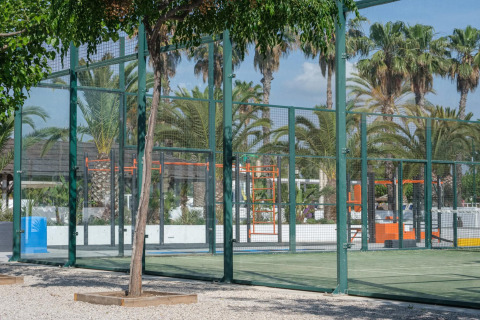 Padelbane med glasvægge og palmer i baggrunden på Camping Estival Vendrell Platja i Spanien.