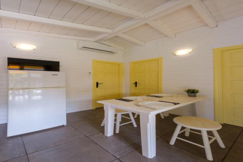 Indvendigt billede af et lyst opholdsrum i CAMPING ESTIVAL VENDRELL PLATJA BUNGALOW 4 STANDARD med spisebord.