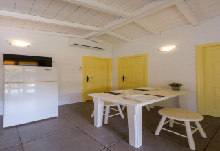 Indvendigt billede af et lyst opholdsrum i CAMPING ESTIVAL VENDRELL PLATJA BUNGALOW 4 STANDARD med spisebord.