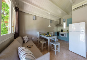 Lichte keuken en eetruimte in een bungalow bij Camping Estival Vendrell Platja, Spanje, met bank en tafel.