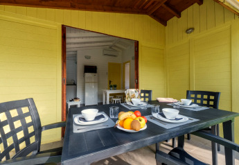 Table extérieure dressée avec vaisselle et fruits au Camping Estival Vendrell Platja Bungalow 4 Standard.