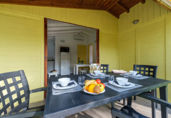 Buitentafel met servies en fruitschaal bij Camping Estival Vendrell Platja Bungalow 4 Standard in Spanje.