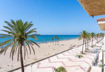 Uitzicht vanaf CAMPING ESTIVAL VENDRELL PLATJA BUNGALOW 4 STANDARD op het strand, palmbomen en de blauwe zee.