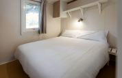Bedroom in Camping Cambrils Playa BUNGALOW OHARA mobile home in Spain with double bed and white bedding.