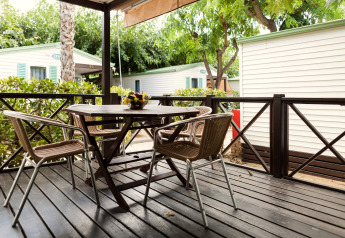 Outdoor deck seating area with table and chairs at Camping Cambrils Playa BUNGALOW OHARA in Spain.