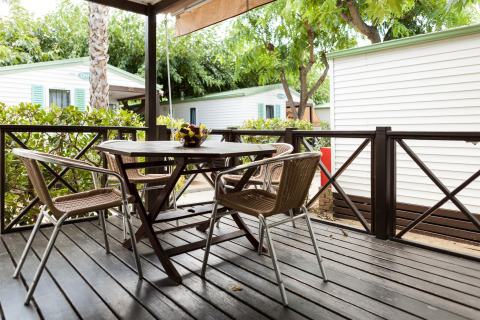 Udendørs terrasse med bord og fire stole på Camping Cambrils Playa BUNGALOW OHARA, Spanien.