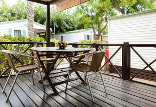 Udendørs terrasse med bord og fire stole på Camping Cambrils Playa BUNGALOW OHARA, Spanien.