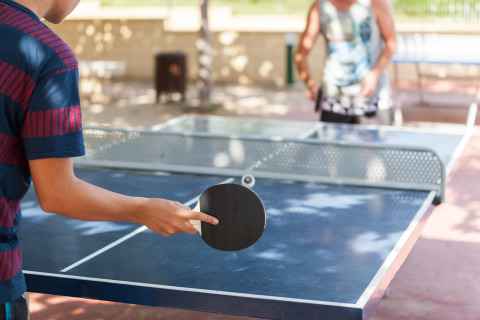 To mennesker spiller bordtennis udendørs på Camping Cambrils Playa BUNGALOW OHARA i Spanien.