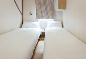 Lichte slaapkamer met twee eenpersoonsbedden in het Camping Cambrils Playa BUNGALOW OHARA mobilhome in Spanje.