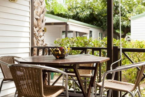 Hyggelig bungalow terrasse ved Camping Cambrils Playa OHARA i Spanien, med havemøbler og frugtskål.
