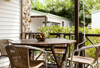 Hyggelig bungalow terrasse ved Camping Cambrils Playa OHARA i Spanien, med havemøbler og frugtskål.