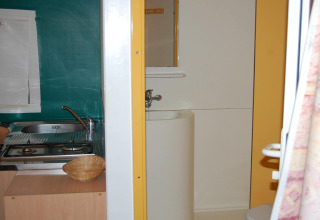 Interno della casa mobile Torre del Sol Tent Pagan in Spagna con cucina e bagno in uno spazio compatto.