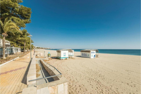 Strandbillede fra mobilhjemmet Torre del Sol Tent Pagan i Spanien med sand, hav og redningsstationer.
