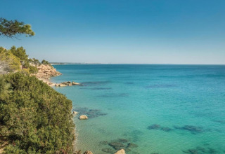 Vista sul mare turchese e sulla costa rocciosa dal mobil home Torre del Sol Tent Pagan in Spagna in una giornata di sole.