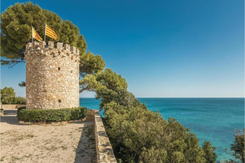 Stenstårn med flag nær Middelhavet ved Torre del Sol Tent Pagan mobilhome i Spanien på en solrig dag.