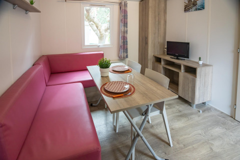 Sala de estar en Torre del Sol COTTAGE PALMA en España con sofá rosa, mesa de comedor y televisor.