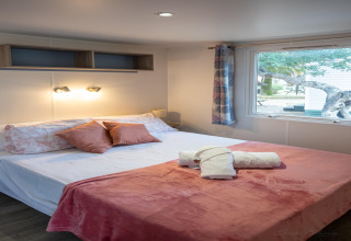 Dormitorio en Torre del Sol COTTAGE PALMA, España, con cama doble, cojines y ventana grande con vista al jardín.