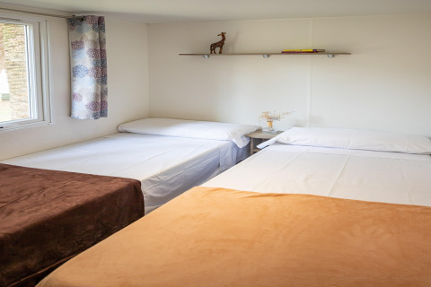 Acogedor dormitorio en Torre del Sol COTTAGE PALMA, España, con tres camas, estantería y decoración sencilla.