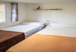 Acogedor dormitorio en Torre del Sol COTTAGE PALMA, España, con tres camas, estantería y decoración sencilla.